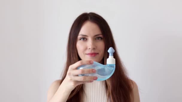 A young woman demonstrates the Neti Pot for treating runny nose and colds. Nasal rinsing, irrigation therapy - Footage, Video