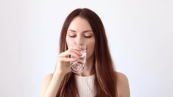 A beautiful young woman drinks pills, vitamins, and badas and washes them down with a glass of water. - Footage, Video