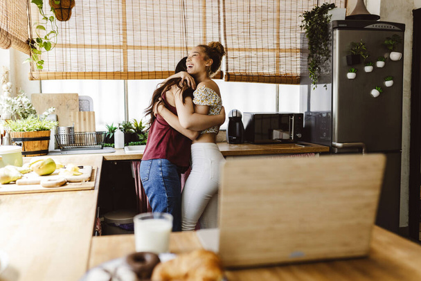 dos mujeres jóvenes lesbianas gay abrazo cocina casa - multirracial lesbiana pareja - - Foto, imagen