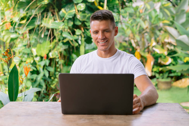 Portrait of a cheerful caucasian man having a video call on a laptop. - Photo, Image