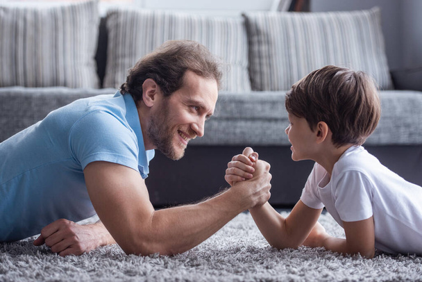 Otec a syn jsou wrestling a usmíval se při trávení času společně doma - Fotografie, Obrázek