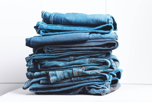 džíny džíny naskládané na bílém pozadí. Trend oblečení, nakupování. - Fotografie, Obrázek
