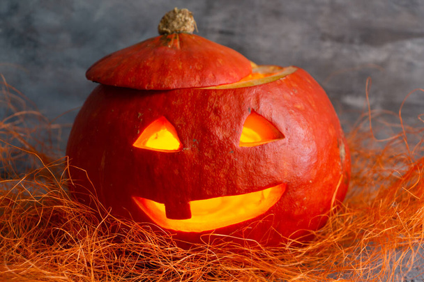 Halloween koncept, složení dýní a svíček na šedém pozadí, Jacks lucerna z dýně, laskavý smích dýně, atmosférické halloween pozadí. Kvalitní fotografie - Fotografie, Obrázek