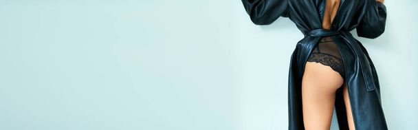 mulher sexy cortada em casaco de couro com costas abertas e calcinhas de renda de pé perto da parede cinza, banner - Foto, Imagem