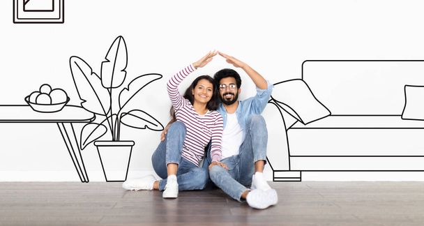 Недвижимость. Счастливая индийская пара, объединяющая руки, создавая крышу, мечтающая о собственном доме рядом с белой стеной с зарисованной гостиной. Панорама с иллюстрацией, коллаж. Ипотека и покупка квартиры - Фото, изображение