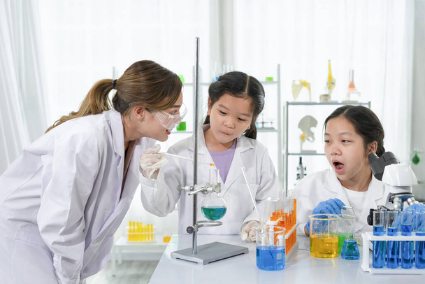 Genç ve çekici Asyalı kadın bir akıl hocası olarak öğrencilere kimya deneylerini, laboratuvar sınıfında fen çalışmalarını öğretmekten zevk alıyor. - Fotoğraf, Görsel