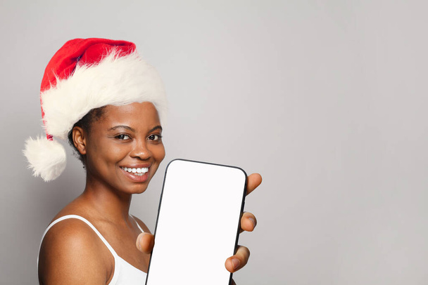 Beautiful Christmas woman Santa with smartphone smiling on white background - Photo, Image
