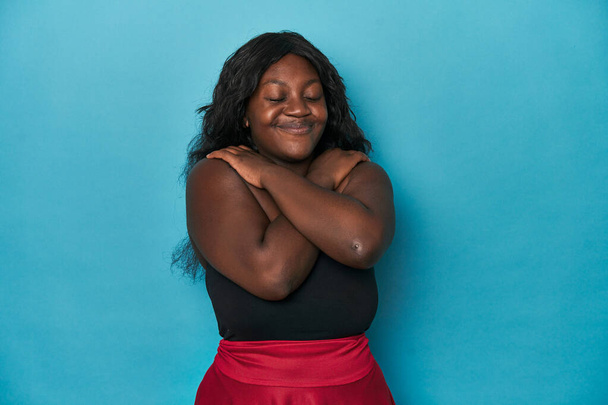 Joven africana americana mujer con curvas abrazos, sonriente despreocupado y feliz. - Foto, imagen