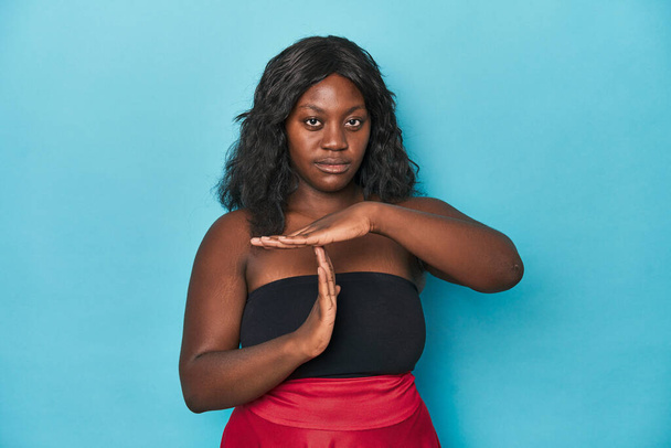 Fiatal afro-amerikai görbe nő mutat egy időkérés gesztus. - Fotó, kép