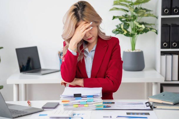 Concept Burnout Syndroom. Aziatische zakenvrouw voelt zich ongemakkelijk werken. Dat wordt veroorzaakt door stress, opgebouwd door mislukt werk en minder rustend lichaam. Raadpleeg een gespecialiseerde psychiater. - Foto, afbeelding