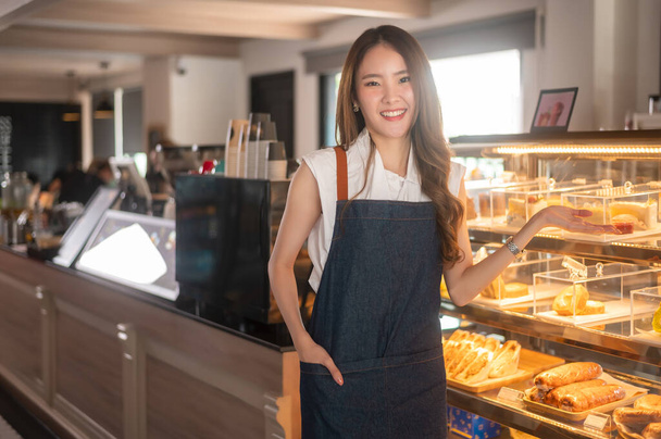 An Asian woman entrepreneur or barista working in modern coffee shop , concept small business  - Фото, зображення