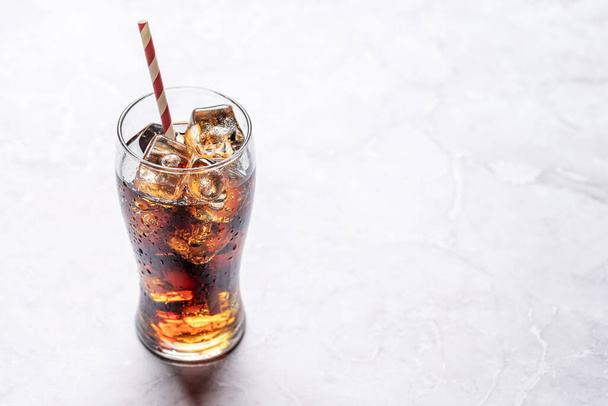 Δροσιστικό ποτήρι κόκα κόλα με πάγο. Σε πέτρινο τραπέζι με χώρο αντιγραφής - Φωτογραφία, εικόνα