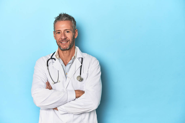 Caucasico di mezza età medico di sesso maschile su uno sfondo blu studio - Foto, immagini