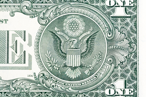 Het zegel van de Verenigde Staten met E Pluribus Unum motto op de keerzijde van één Amerikaanse dollar bill. - Foto, afbeelding