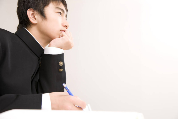 portrait of young Japanese boy in school uniform studying at school - Foto, Imagem