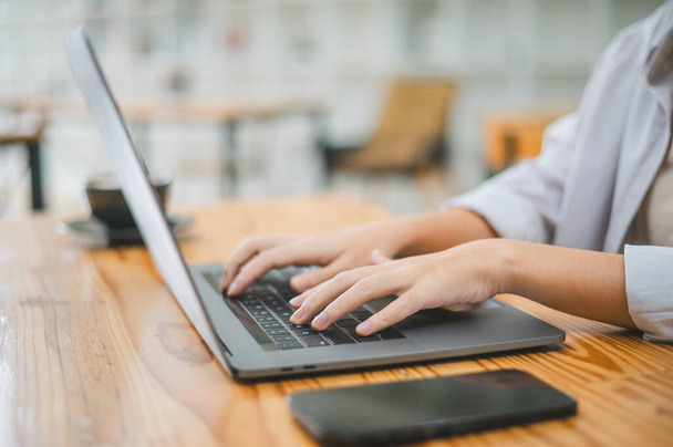 Lähikuva opiskelijan kädestä töissä kannettavalla tietokoneella. Oppiminen ja tiedon etsiminen internetistä. - Valokuva, kuva