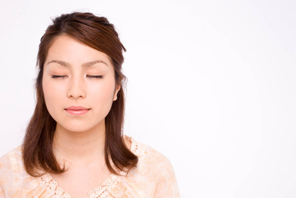 beautiful young asian woman  with eyes closed  isolated - Foto, imagen