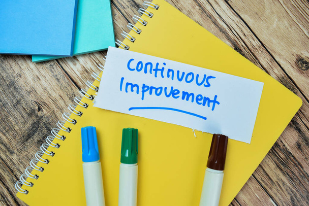 Concept of Continuous Improvement write on sticky notes isolated on Wooden Table. - Photo, Image
