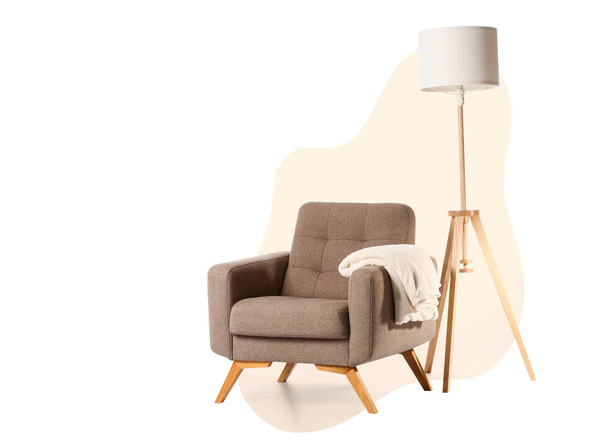 Cómodo sillón con cuadros y lámpara de pie sobre fondo blanco - Foto, imagen