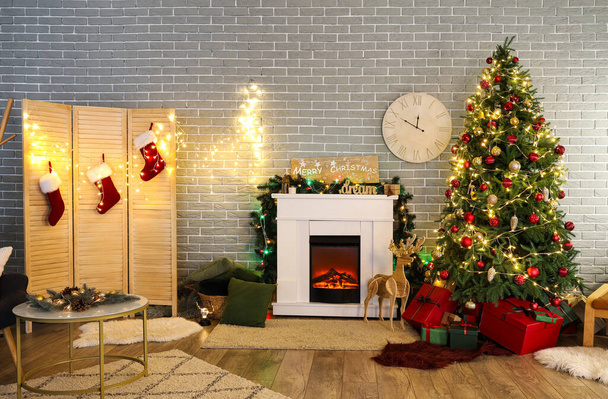 Interior de la sala de estar con árbol de Navidad, chimenea, regalos y pantalla plegable - Foto, imagen