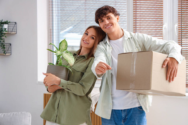 Mladý pár s klíči a stěhovací box v novém bytě - Fotografie, Obrázek