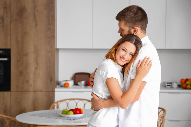 Happy couple in love hugging in kitchen - Photo, Image