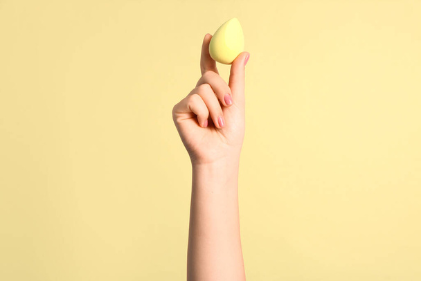 Naisten käsi keltainen meikki sieni beige tausta - Valokuva, kuva