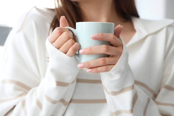 Jeune femme avec une tasse de thé chaud à la maison, gros plan
 - Photo, image