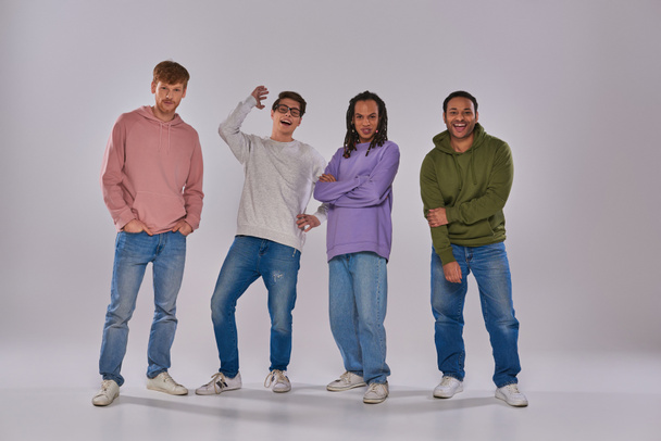 four young multicultural man in casual outfits standing and laughing at camera, cultural diversity - Photo, Image