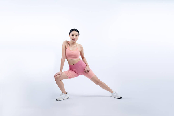 Young attractive asian woman in sportswear stretching before fitness exercise routine. Healthy body care workout with athletic woman warming up on studio shot isolated background. Vigorous - Photo, Image