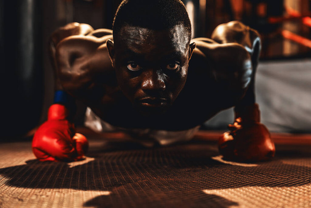 Afrika kökenli siyah erkek boksör boks antrenmanından önce kırmızı eldivenle ısınıyor. Fitness ve dövüş sanatı, ter ve kaslı vücut adam boksör boksör şınav egzersizi. Impetus - Fotoğraf, Görsel