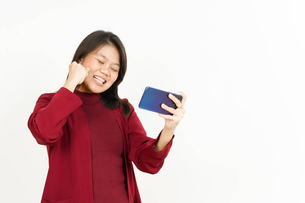 Гра на мобільному телефоні красивої азіатки в червоній сорочці ізольовані на білому
 - Фото, зображення
