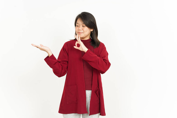 Montrant produit recommandé sur la paume ouverte de belle asiatique femme portant chemise rouge - Photo, image
