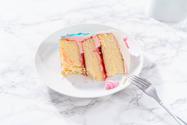 Tranche d'un gâteau à la vanille 3 couches sur le thème de la sirène avec queues de sirène au chocolat et coquillages sur une assiette blanche. - Photo, image