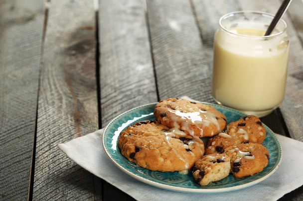 Cookies on plate with jar of condensed milk on wooden background - Foto, immagini