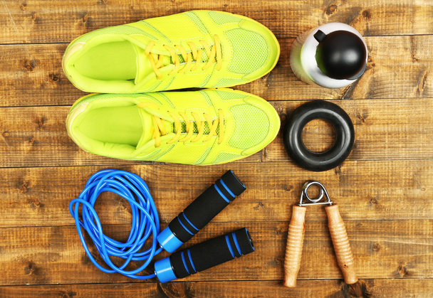 Shoes and sports equipment on wooden floor, top view - Valokuva, kuva