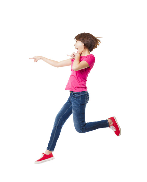 Νεαρή γυναίκα ευτυχισμένη jumping και δείχνοντας - Φωτογραφία, εικόνα