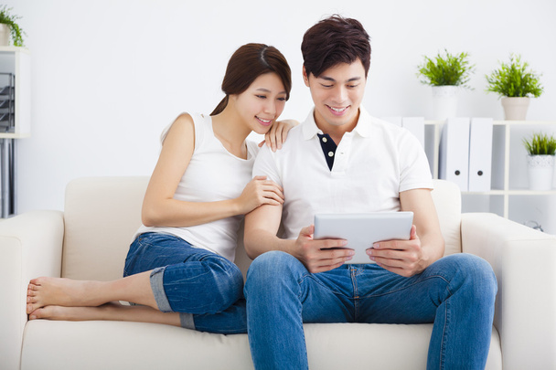 asijský pár na pohovce s tabletovým počítačem - Fotografie, Obrázek
