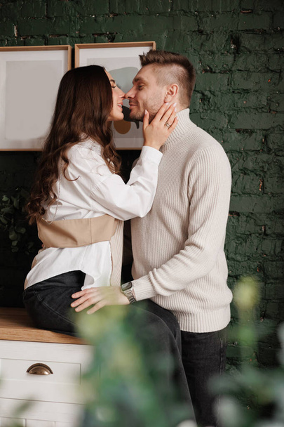 Sevgililer Günü. Mutlu çift İskandinav evinde nazikçe sarılıyor. Sağlıklı ilişkileri olan genç bir adam ve kadın romantik bir buluşmada vakit geçirip yıldönümünü kutluyorlar.. - Fotoğraf, Görsel