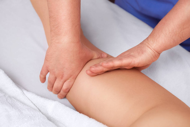 Il massaggiatore effettua un massaggio anticellulite sulla natica e sulle cosce del paziente. Trattamento del peso in eccesso. - Foto, immagini
