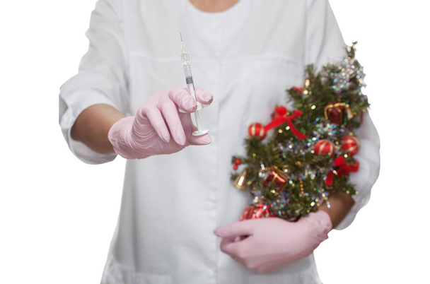 O cosmetologist médico prende uma seringa para a injeção e uma árvore de Natal decorada pequena no salão de beleza. Cuidados cosméticos da pele. - Foto, Imagem