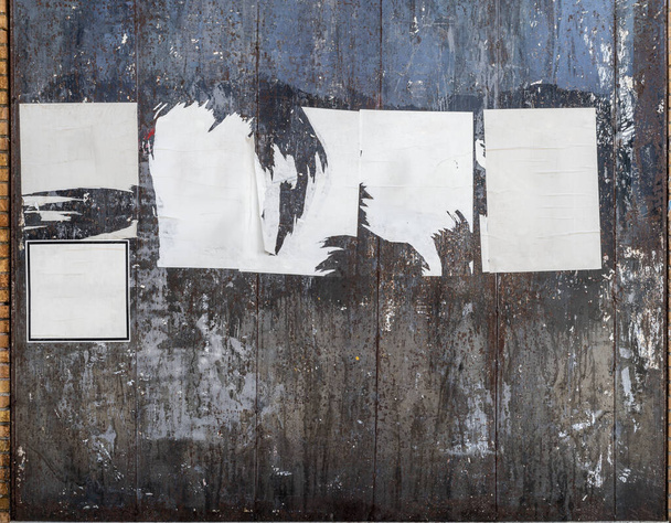 Blank torn and crumpled posters on a black metallic wall. - Photo, Image