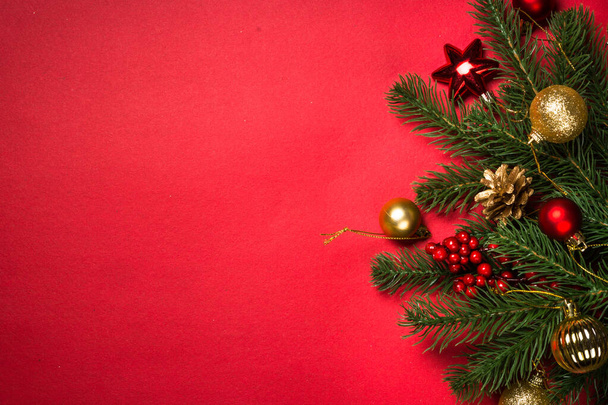 赤い背景にモミの木や装飾が施されたクリスマスの背景。テキストのスペース付きのトップビュー. - 写真・画像