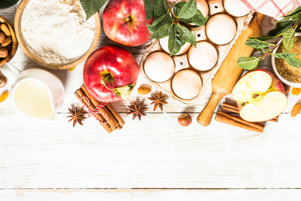 Vallen bakken. Herfst bakconcept. Ingrediënten voor het bakken - bloem, suiker, appels en specerijen. Bovenaanzicht aan witte houten tafel. - Foto, afbeelding