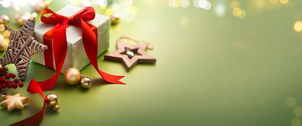 Noel tebrik kartı ya da Noel Sancak Tasarımı - Açık yeşil zemin üzerinde sihirli ışıklarla süslenmiş hediye kutusu  - Fotoğraf, Görsel