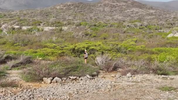 Een vrouw aan de rauwe kust van een eiland in het Caribisch gebied - Video