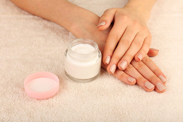 Female hands with jar of cream on fabric background - Foto, Bild