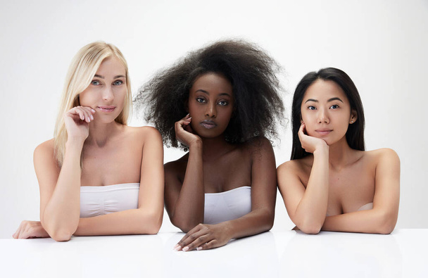 Portrait of beautiful young multiracial women, caucasian asian and african against white background. Diversity. Concept of multi ethnic beauty, natural, spa, cosmetology, wellness, ad - Foto, afbeelding