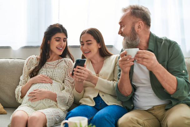 grey bearded father looking at her daughter while she looking at her partner's phone, ivf concept - Φωτογραφία, εικόνα