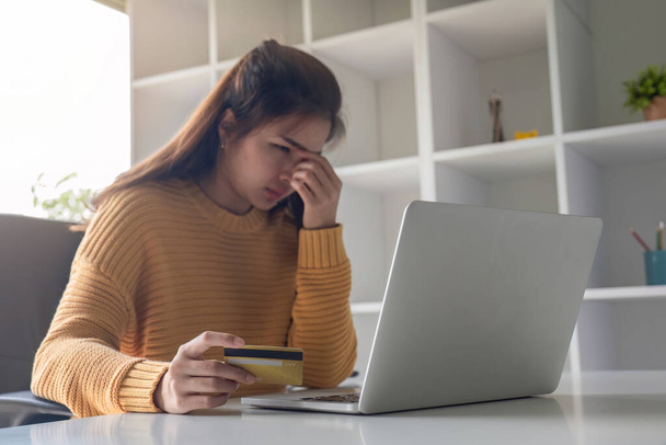 Nuori aasialainen nainen stressaantunut maksaa luottokortilla online-ostoksia Kun edessä kalliita kuluja. - Valokuva, kuva